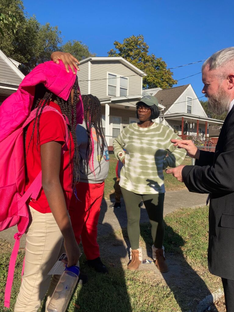 A Christian evangelist preaching the Gospel in a local neighborhood. A church member sharing the Gospel with a person on the street.