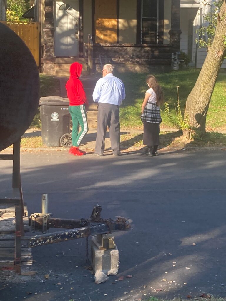 A Christian evangelist preaching the Gospel in a local neighborhood. A church member sharing the Gospel with a person on the street.