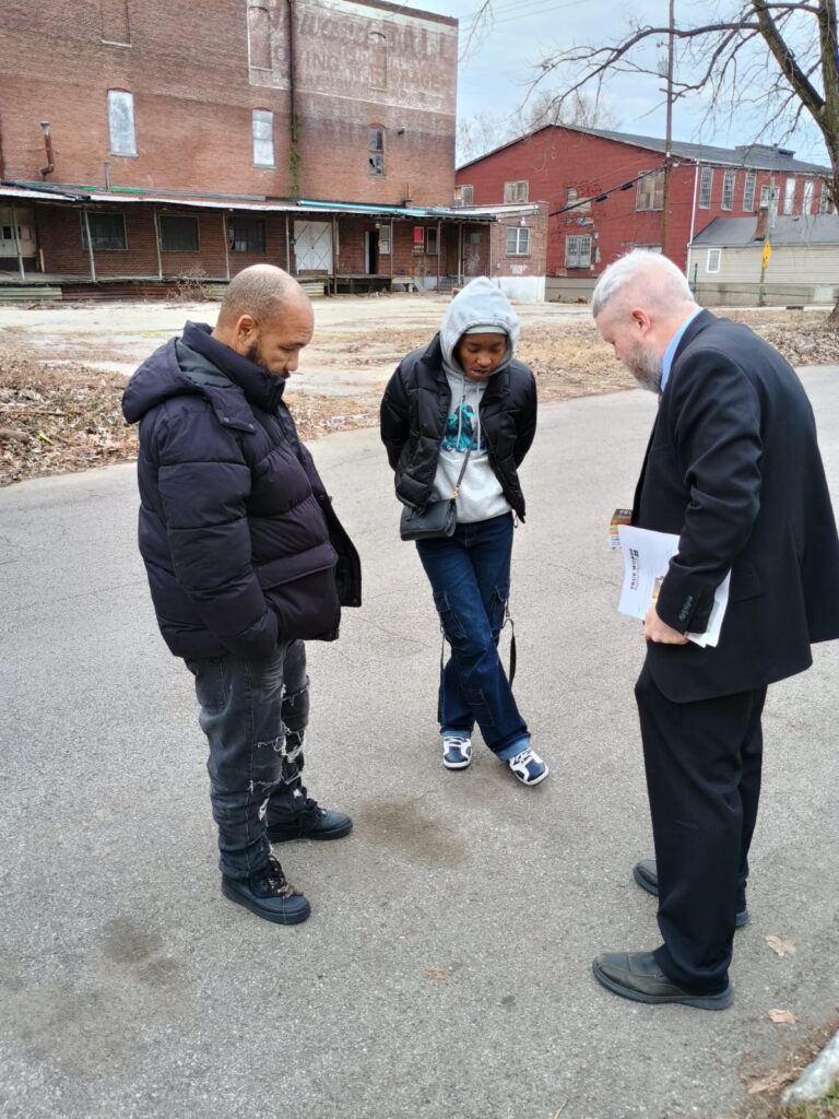 Joshua Tapp preaching the Gospel to a man and woman right around the corner from True Words Baptist Church.