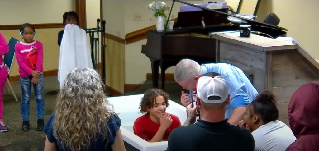 youth getting baptized in water at true words baptist church in louisville, kentucky