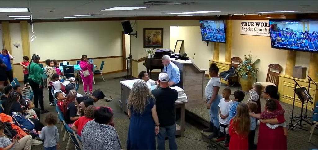 A person being baptized in water at True Words Baptist Church in Louisville, Kentucky.