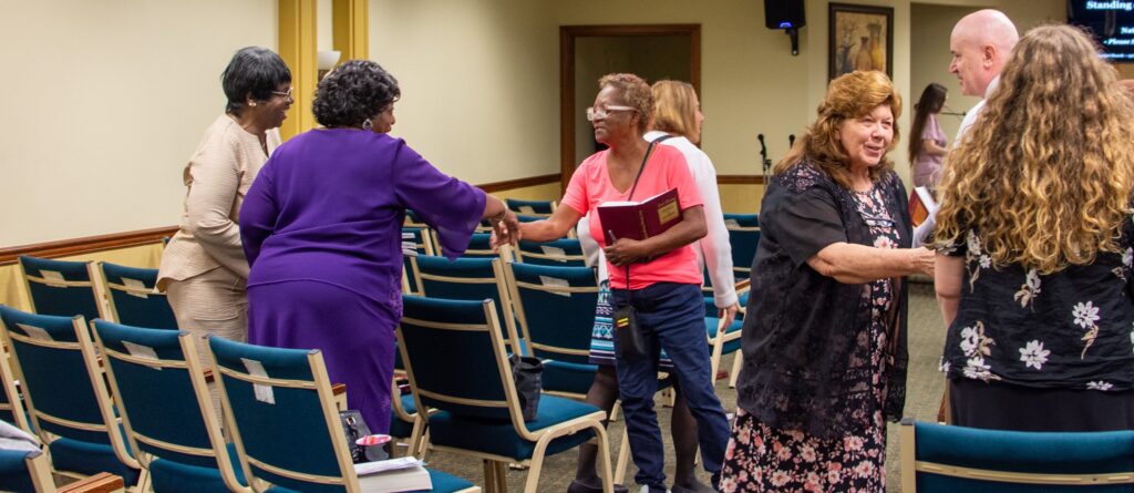 members at true words baptist church greeting each other at sunday morning worship service